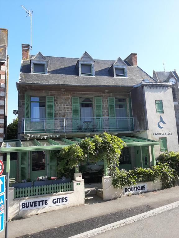 卡羅萊的住宿－Les Madeleines，街道上一座带绿色百叶窗的大型建筑