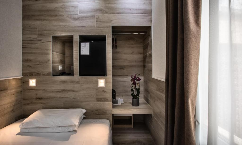 sypialnia z łóżkiem i drewnianą ścianą w obiekcie Eurohotel w Mediolanie