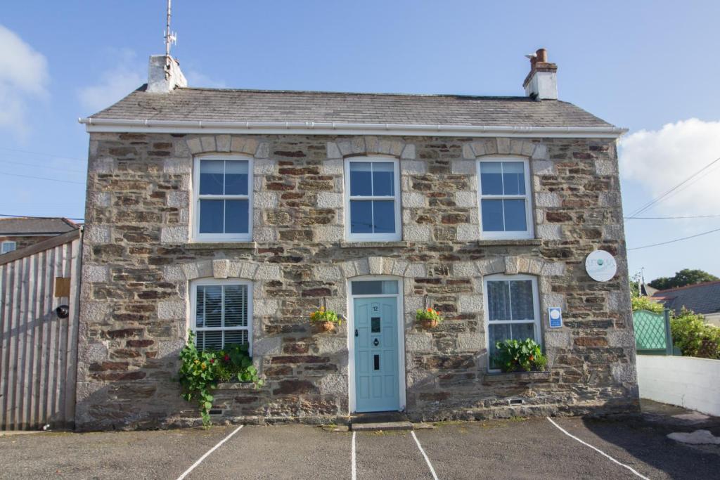 an old stone house with a blue door at Utopia Apartments in Perranporth
