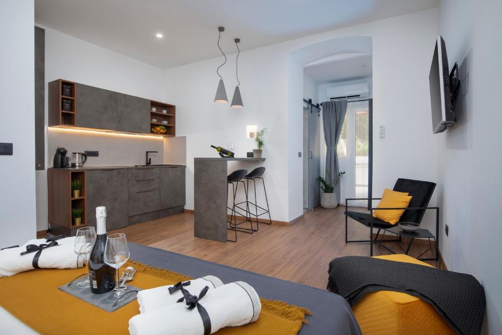 een woonkamer en een keuken met een tafel en stoelen bij Deluxe Rooms and Apartments Korzo in Pula