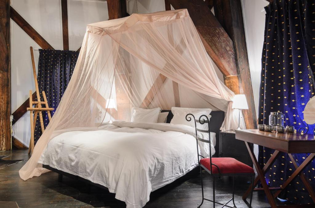 a bedroom with a bed with a mosquito net at Mondriaanmolen, a real Windmill close to Amsterdam in Abcoude