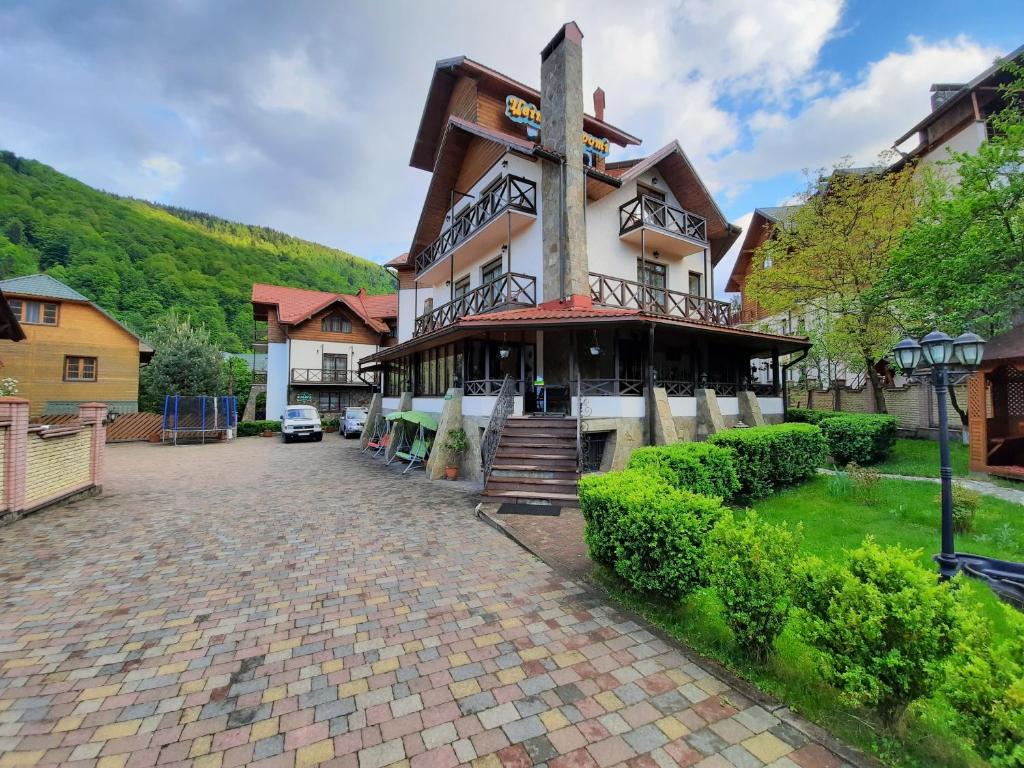 a large building on a brick walkway in front at Tsvit Paporoti in Yaremche