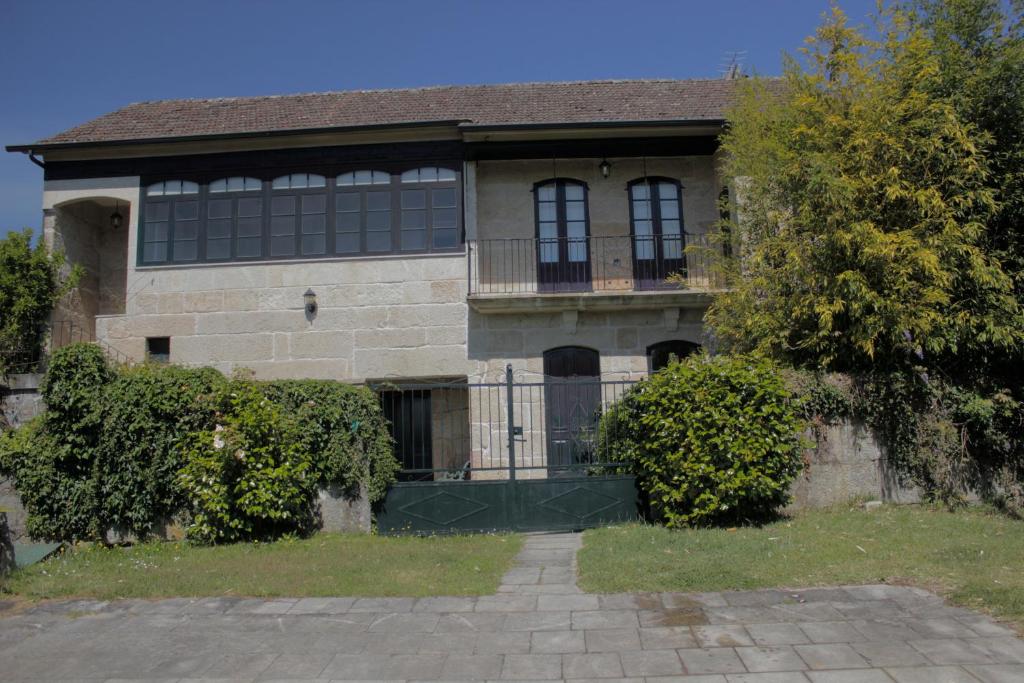 ein großes Backsteinhaus mit einem Balkon und einem Tor in der Unterkunft O cuco de Mondariz in Mondariz