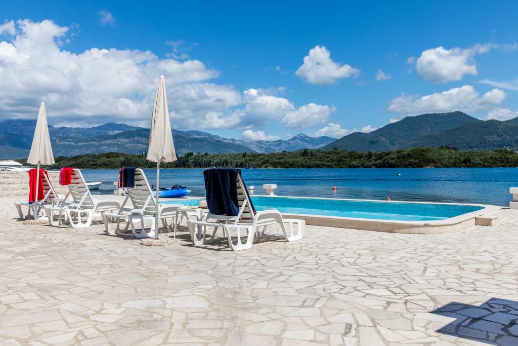 une rangée de chaises longues et une piscine dans l'établissement Apartments Tamaris, à Tivat