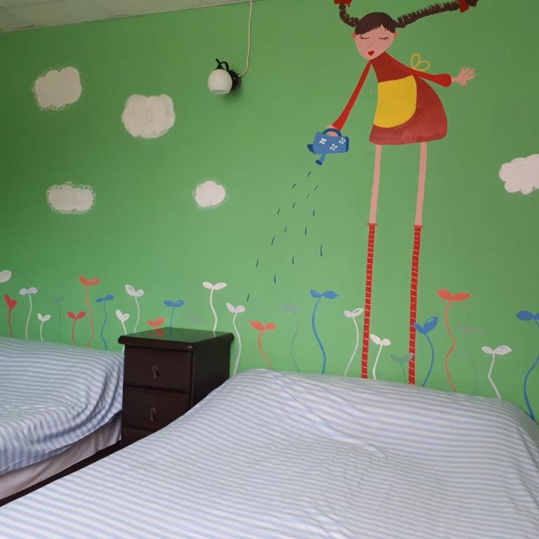a bedroom with a wall mural of a girl standing in the rain at Taroko Susi Space in Xincheng