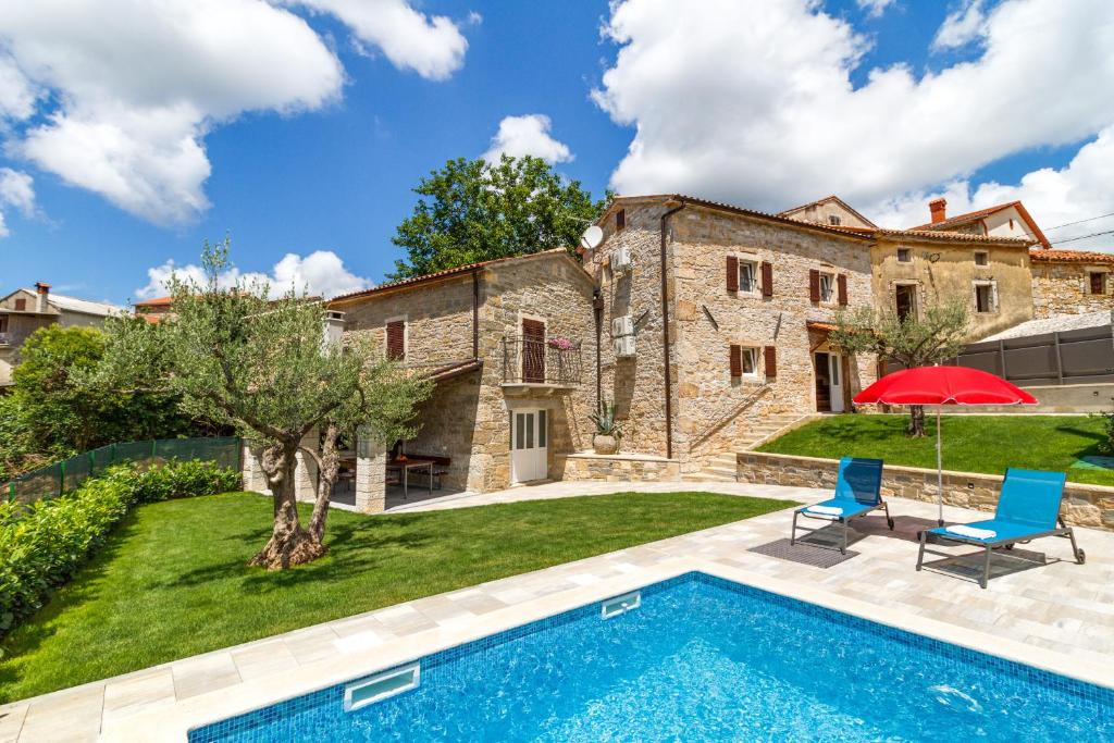 stary kamienny dom z basenem przed nim w obiekcie Villa Zoro with a lovely garden and a private POOL in the middle of Istria w mieście Pazin