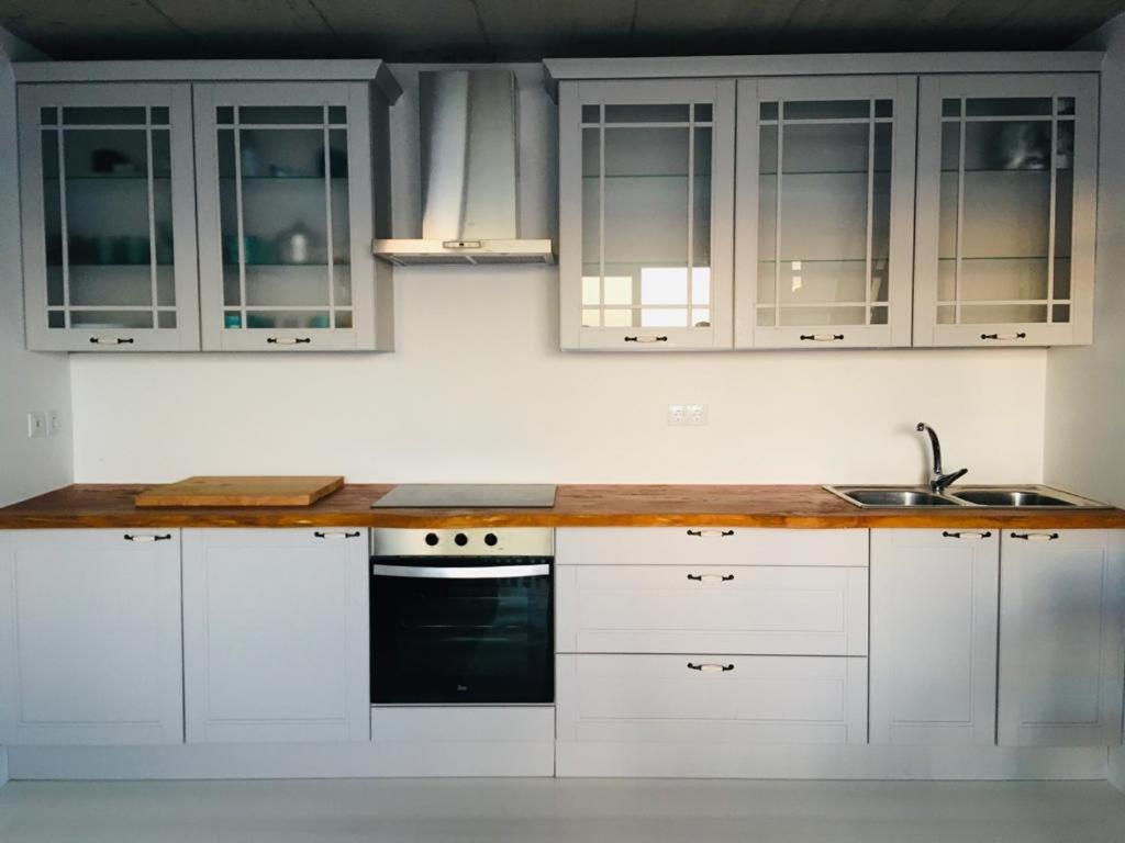 a kitchen with white cabinets and a sink at CASA DO MAR in Jardim do Mar