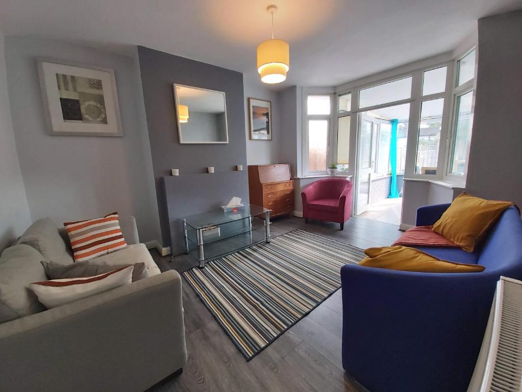 a living room with two couches and a table at Exton House -Huku Kwetu 4 Bedroom House- Luton Airport - Group Accommodation - up to 7 people in Luton