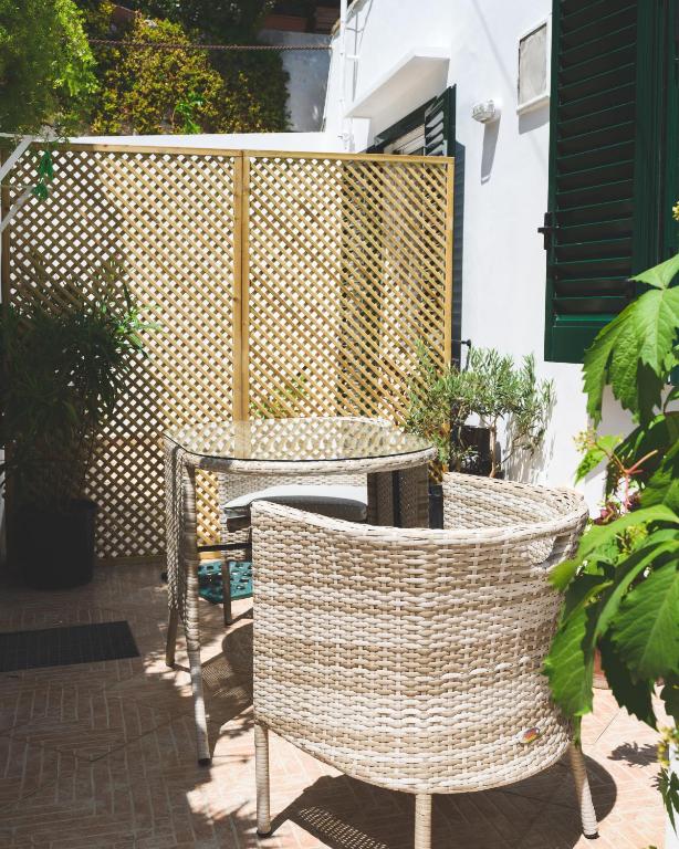 a patio with a table and chairs and a fence at Parco Augusto in Capri