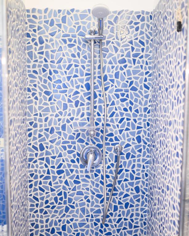 a shower with a blue and white patterned shower curtain at Parco Augusto in Capri