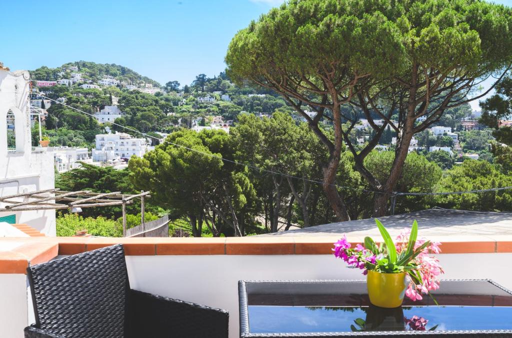 a table with a vase of flowers on a balcony at Parco Augusto in Capri