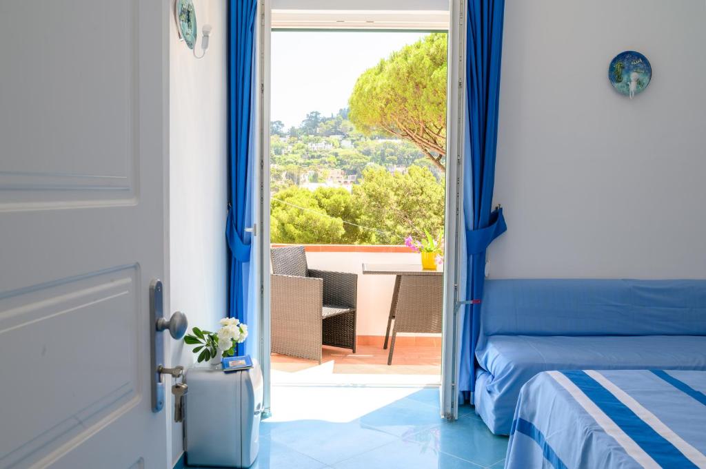 a bedroom with a bed and a view of a patio at Parco Augusto in Capri
