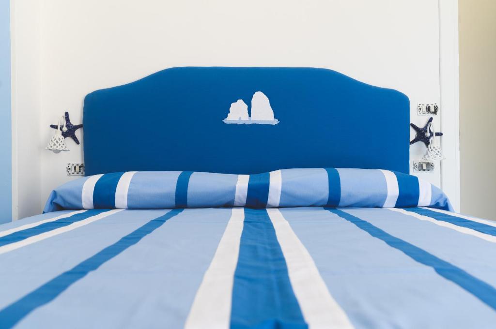 a blue bed with a blue headboard with sails on it at Parco Augusto in Capri