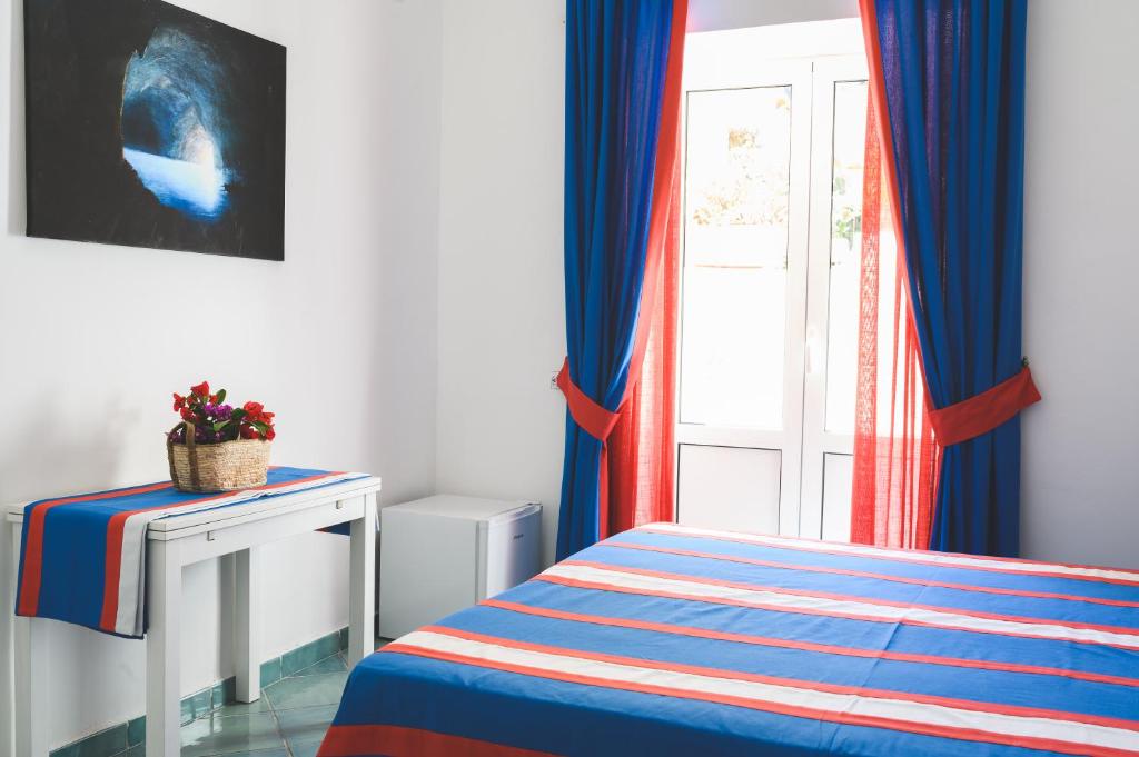 a bedroom with a bed and a window with curtains at Parco Augusto in Capri