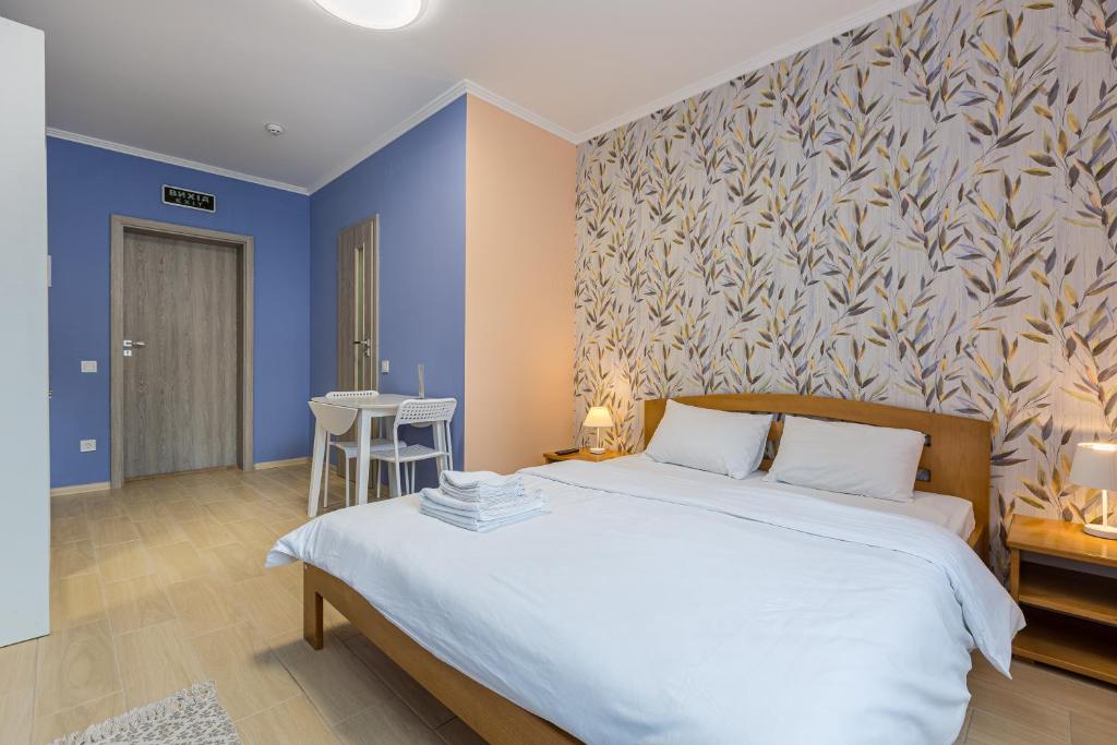 um quarto com uma grande cama branca e paredes azuis em BonApart em Lviv