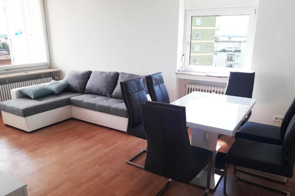 ein Wohnzimmer mit einem Sofa, einem Tisch und Stühlen in der Unterkunft Stadtwohnung in Eppelheim bei Heidelberg in Eppelheim