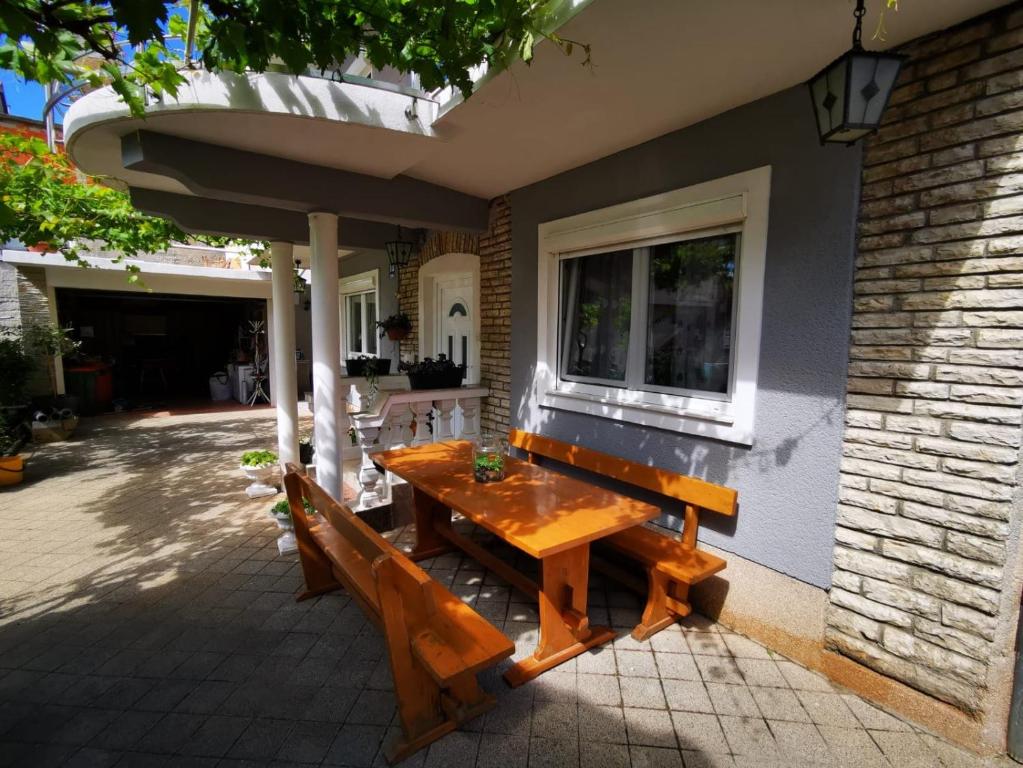 a wooden table and bench outside of a house at Apartments Sanda Tribunj in Tribunj