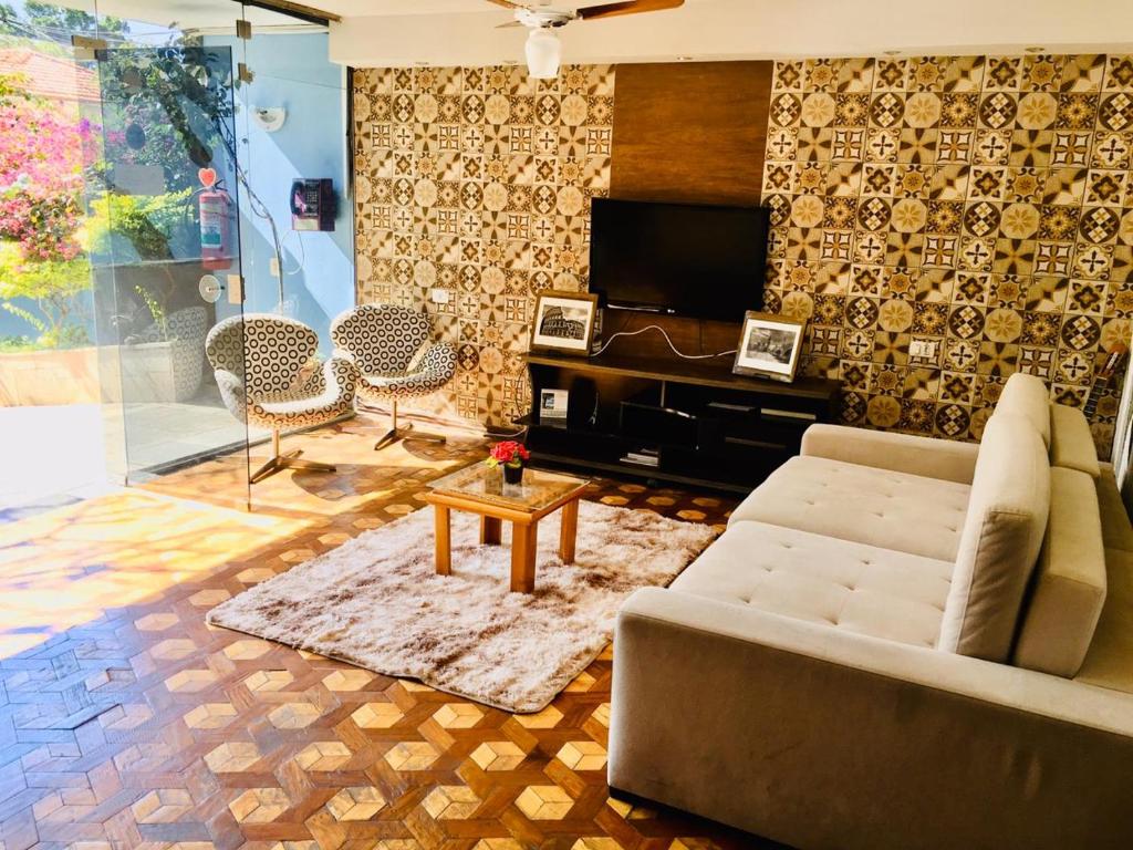 a living room filled with furniture and a fire place at Praça da Árvore Hostel in São Paulo