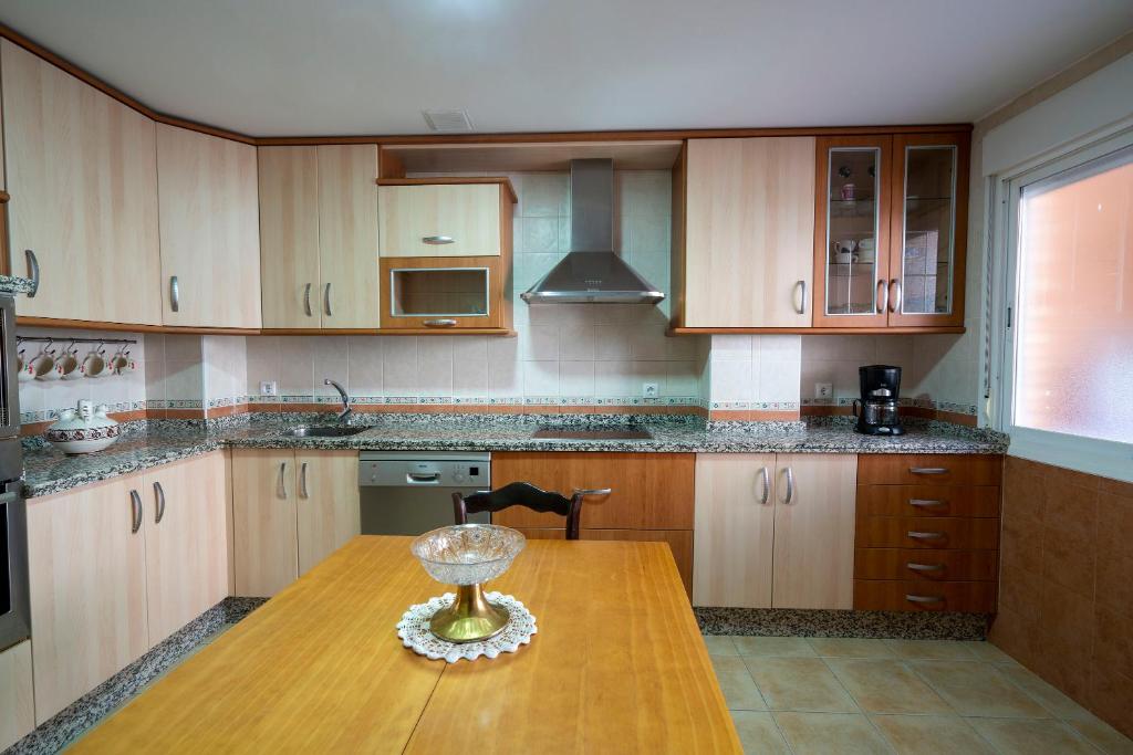 eine Küche mit Holzschränken und einem Holztisch in der Unterkunft Casa Montesol in Cáceres