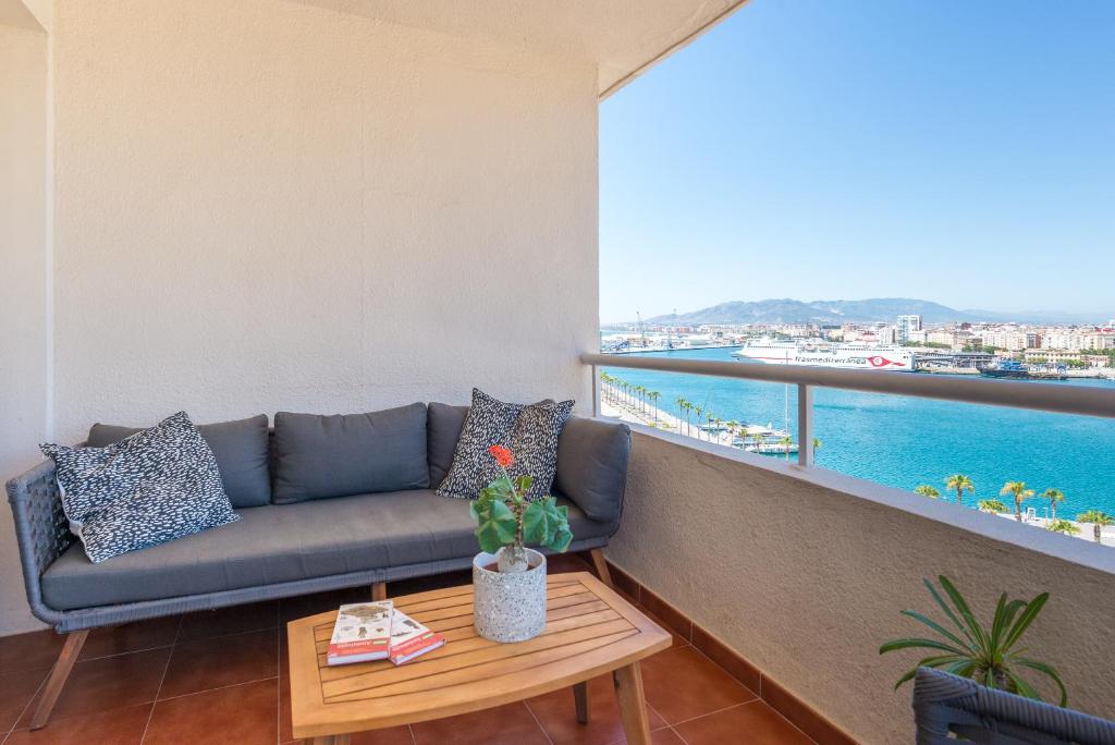 sala de estar con sofá y vistas al agua en LU&CIA City Beach Puerto 3, en Málaga