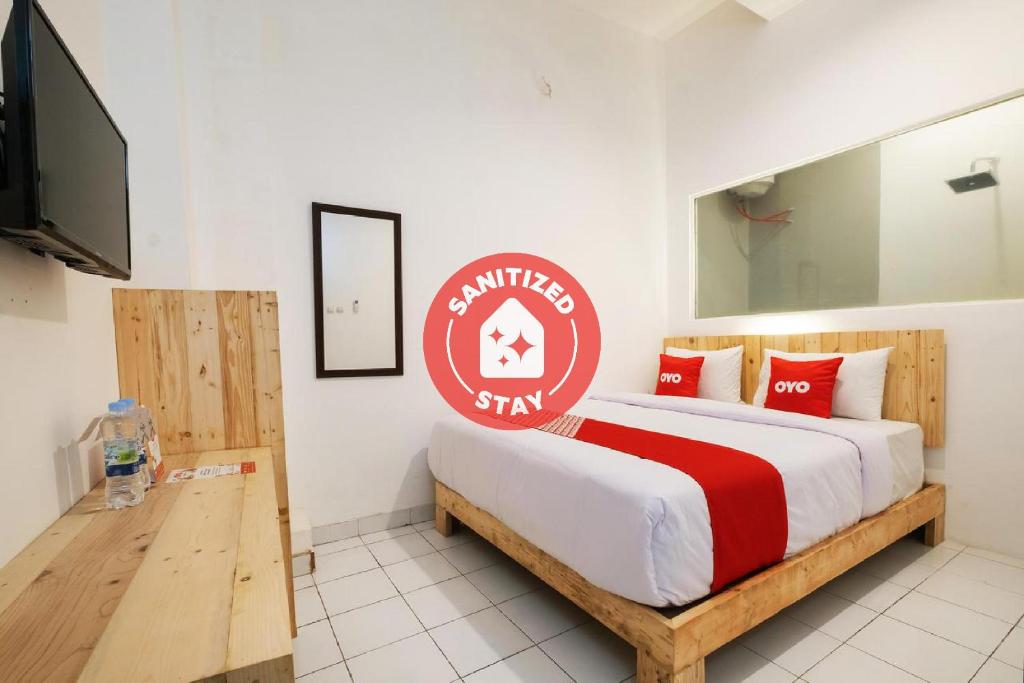 um quarto com uma cama com uma placa em OYO 2041 Griya Aneka em Yogyakarta