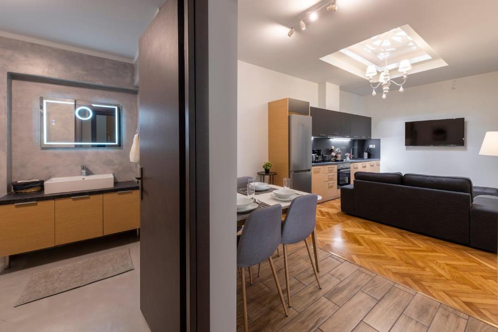 uma cozinha e sala de estar com uma mesa e um sofá em Modern 5BD Apartment in the Heart of Athens em Atenas