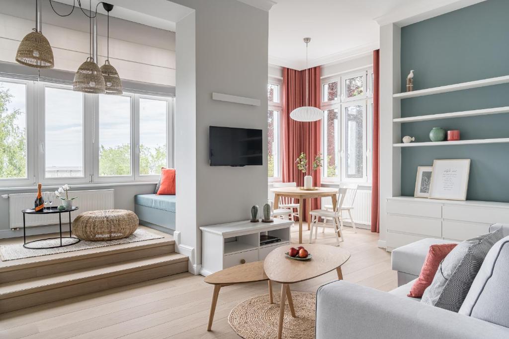 ein Wohnzimmer mit einem Sofa und einem Tisch in der Unterkunft Sanhaus Apartments - Apartament Playa 1 z widokiem na morze in Sopot