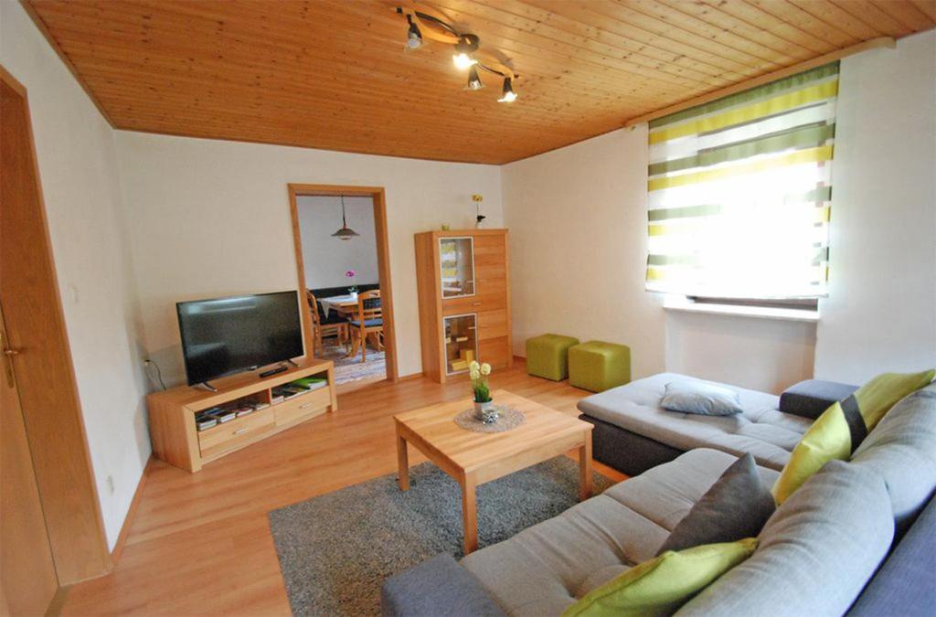 a living room with a couch and a tv at Landhaus Christina in Rumbach