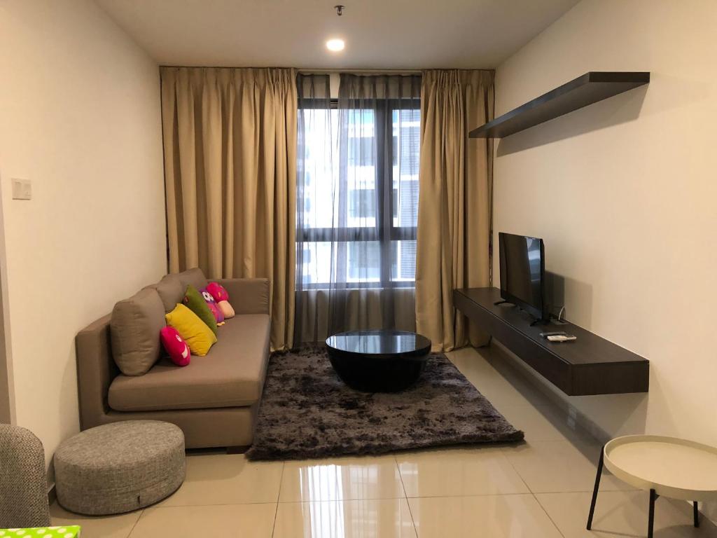 a living room with a couch and a television at Sun-Suite in Shah Alam