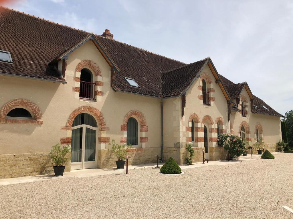 une grande maison avec une allée en face de celle-ci dans l'établissement Gite du Domaine de la Maison Neuve, à Saint-Jean-Saint-Germain