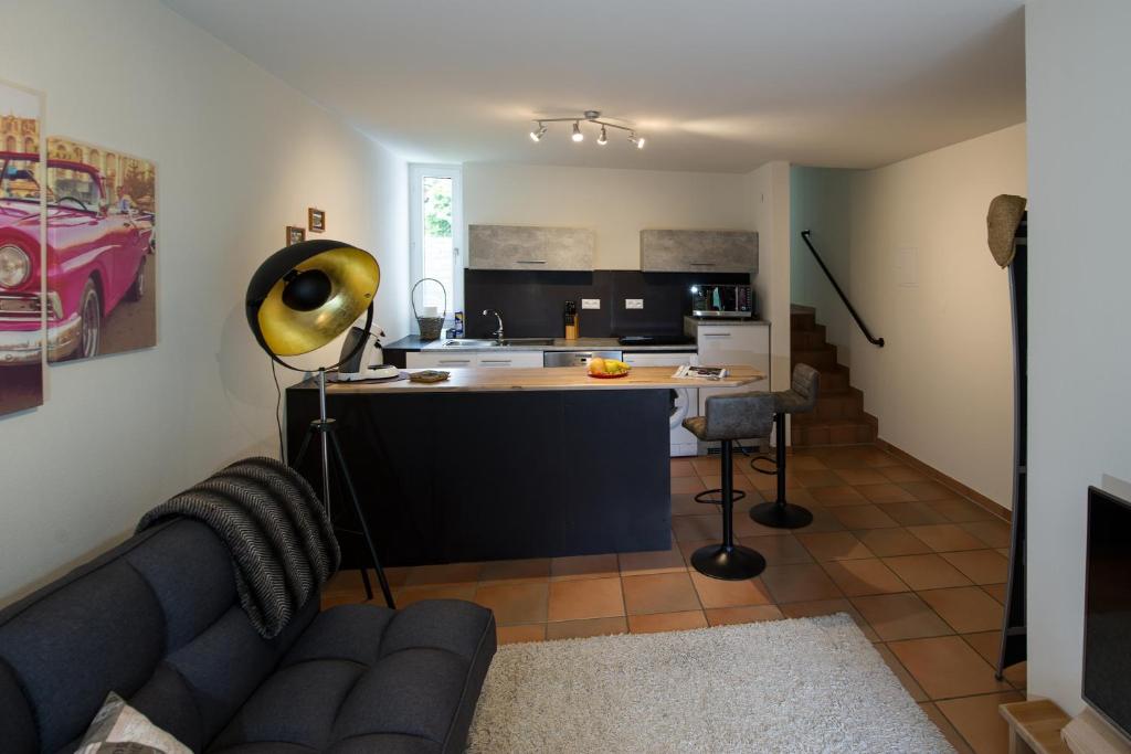 een woonkamer met een bank en een keuken bij Ferienappartement in der Spielestadt in Ravensburg