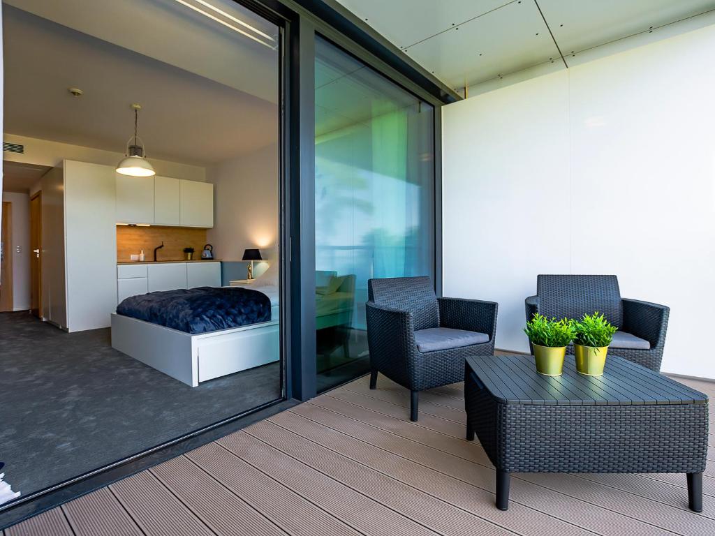 a bedroom with a bed and a chair and a table at VacationClub - Seaside Apartament 109 in Kołobrzeg