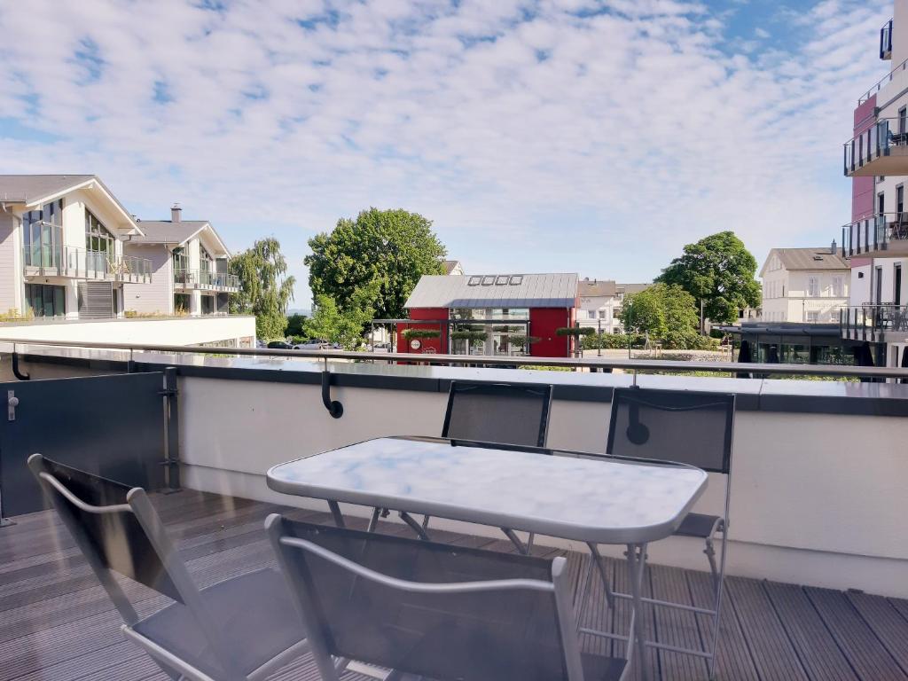 einen Balkon mit einem Tisch und Stühlen auf dem Dach in der Unterkunft Ferienwohnung Haffduurn in Glowe