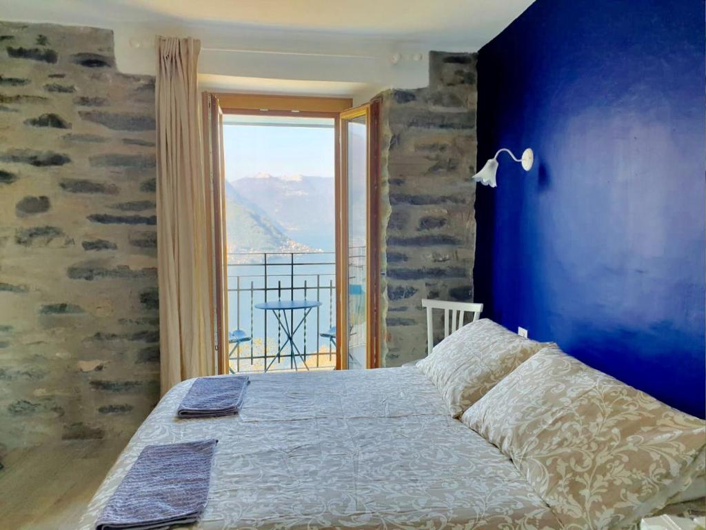 a bedroom with a bed with a blue wall at Ca Bossa Molina in Faggeto Lario 