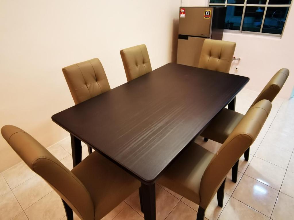 einen schwarzen Esstisch mit braunen Stühlen in der Unterkunft 12 pax Bidor Totoro House in Bidur