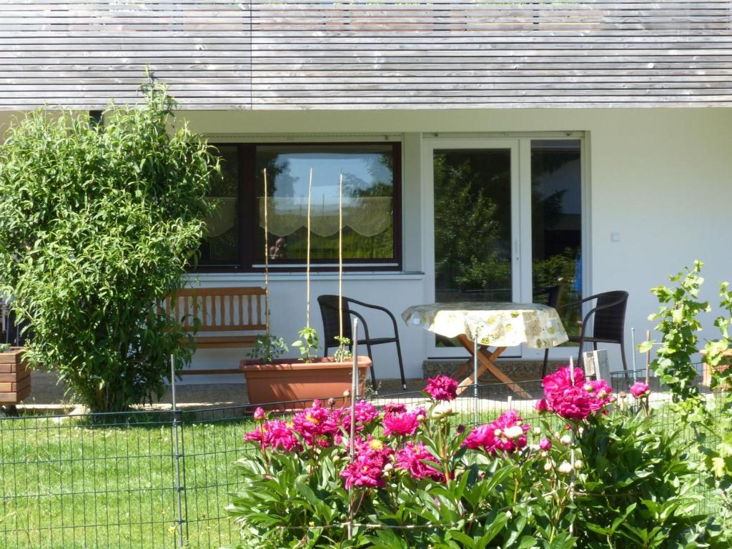 a house with a table and flowers in the yard at Ferienwohnung Paula in Lichtenstein