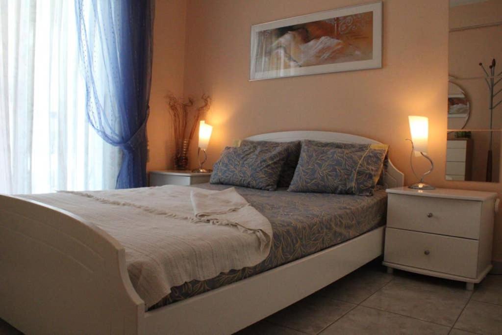 1 dormitorio con 1 cama con 2 lámparas y una ventana en Holiday Apartment Flogita, en Flogita