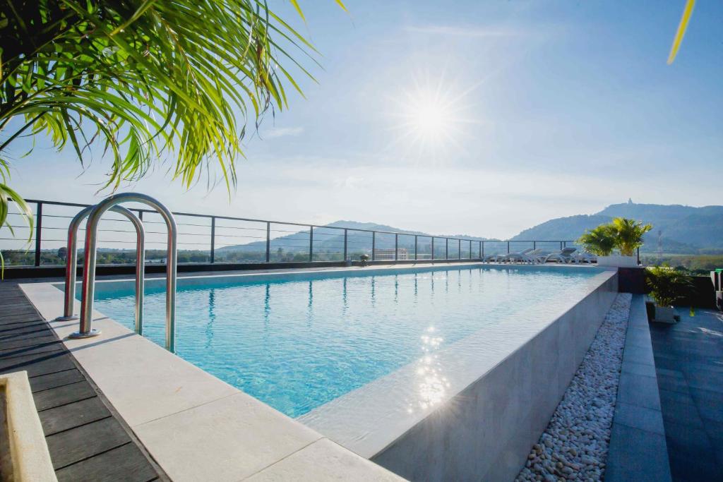 a swimming pool with a view of the mountains at NOON Village Tower 1 in Chalong