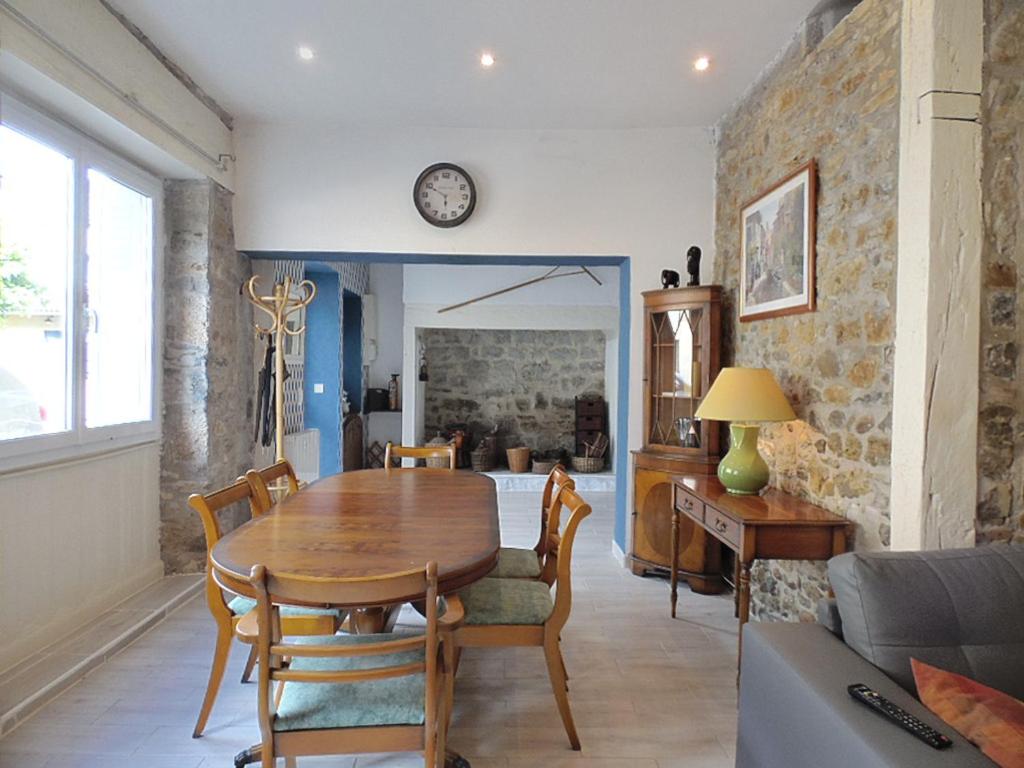 a dining room with a wooden table and chairs at Le Coustalou in Puybrun