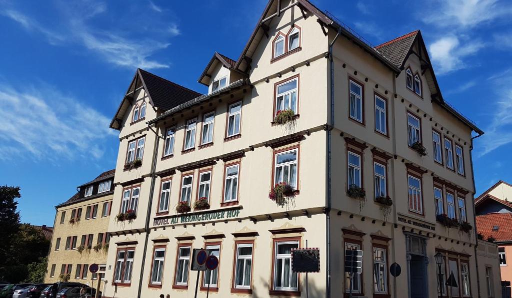 ein großes weißes Gebäude mit Blumen an den Fenstern in der Unterkunft Garni-Hotel Alt Wernigeröder Hof in Wernigerode