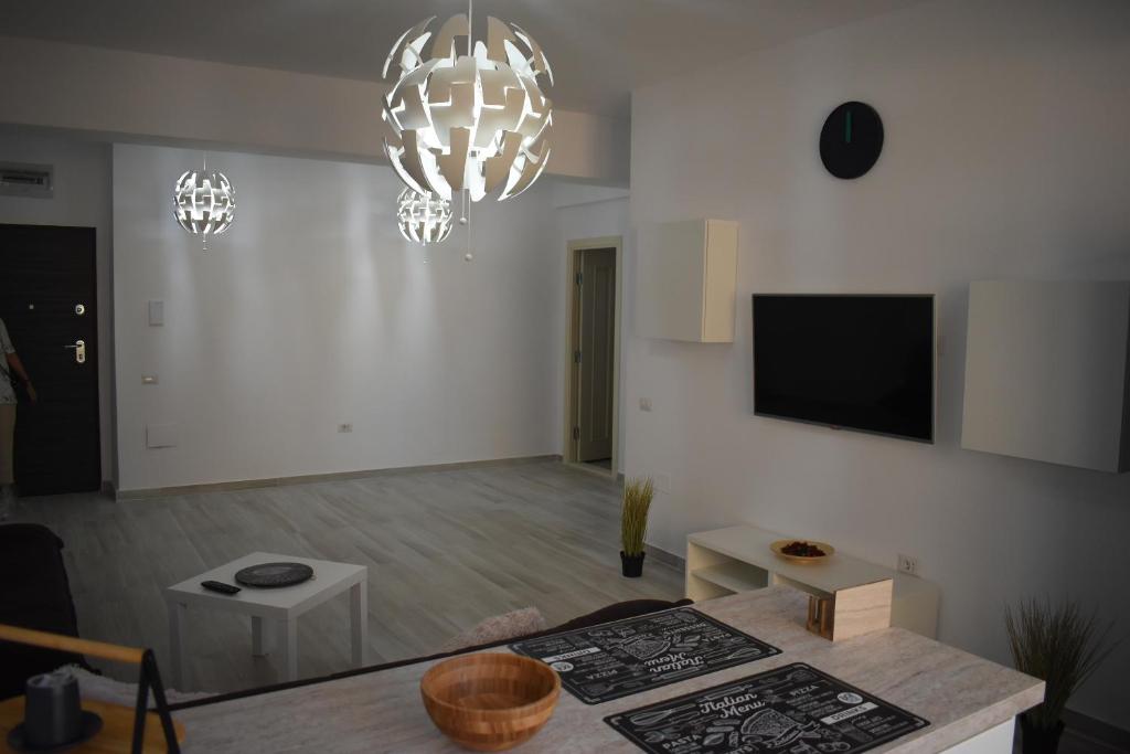 a living room with white walls and a flat screen tv at Apartment By The Lake with a View in Mamaia