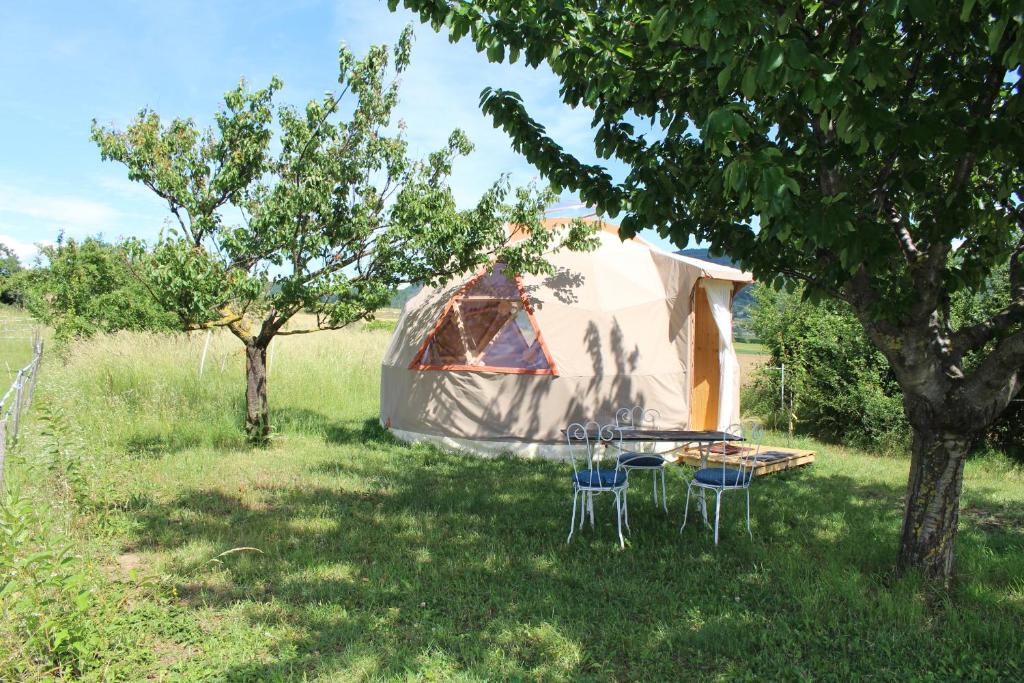 einen Tisch und Stühle vor einem Zelt in der Unterkunft L'Attrape Rêve Insolite in Saint-Vincent-de-Barrès