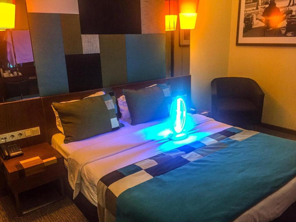 a room with a bed with a light on it at Collage Pera Hotel in Istanbul