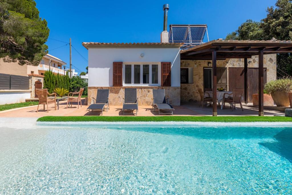 Villa con piscina frente a una casa en Sa Gola, en Canyamel