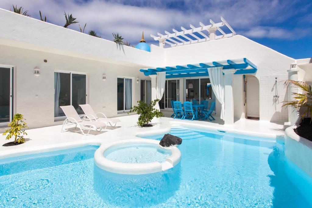 a villa with a swimming pool and a house at Villa 34 in Corralejo