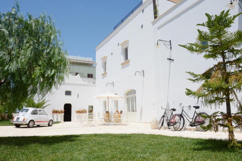 Biały budynek z rowerami zaparkowanymi przed nim w obiekcie Casina Colosso - relais&more - w mieście Nardò
