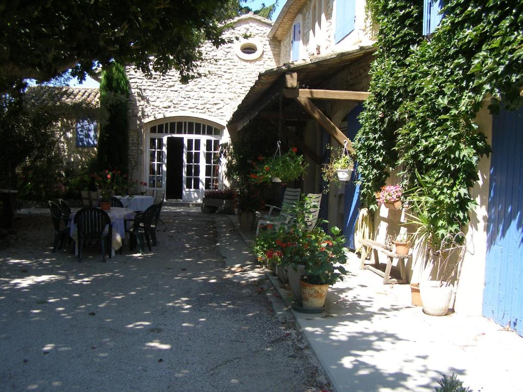 eine Terrasse eines Hauses mit einem Tisch und Stühlen in der Unterkunft L'Oustau de Mistral in Eyragues