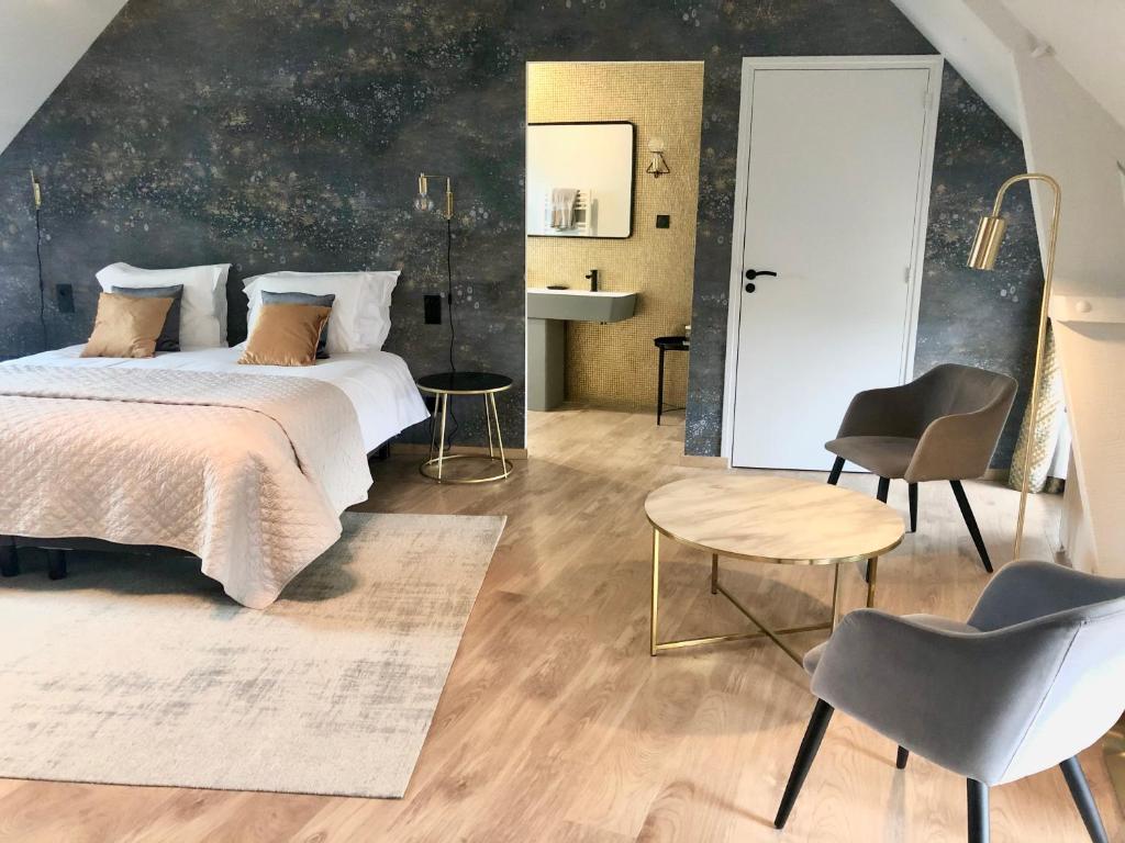 1 dormitorio con 1 cama, mesa y sillas en La Maison Gervaiserie & Spa, en Réville