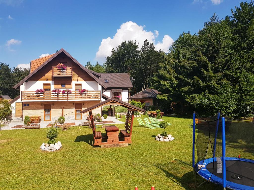 une maison avec une aire de jeux en face dans l'établissement Guesthouse Green Valley, aux lacs de Plitvice