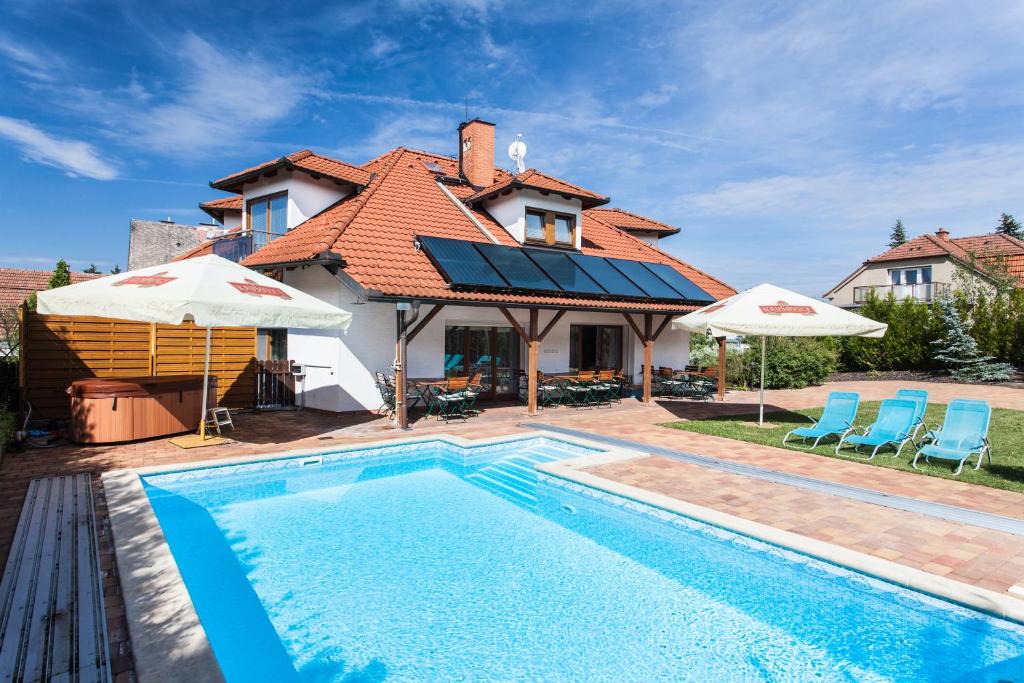 a villa with a swimming pool in front of a house at Depandance Hotel u Crlíků in Tetčice
